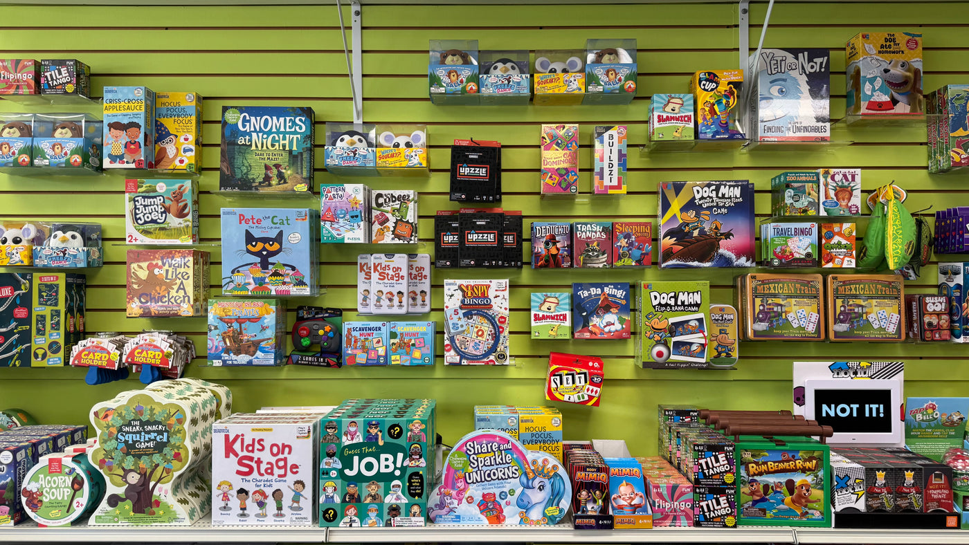 Display of children's toys and games on a green wall
